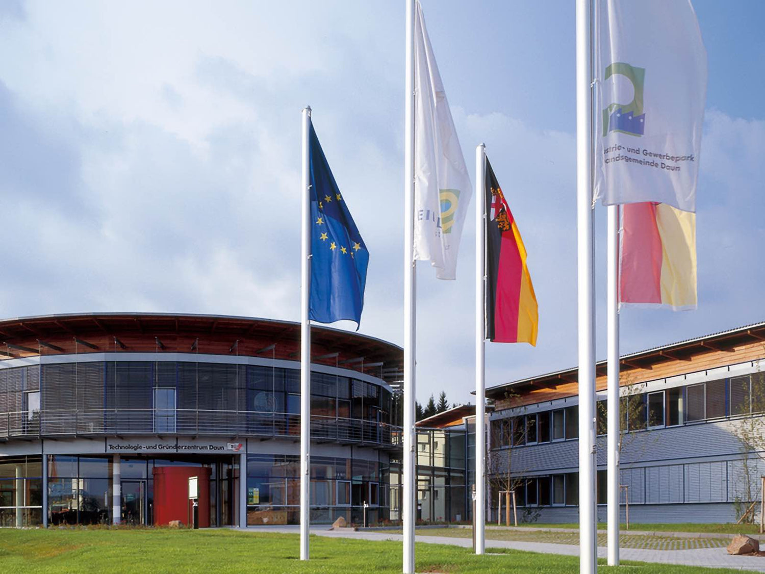 Bürogebäude von mh bautenschutz im Technologie- und Gründerzentrum Daun mit Fahnen vor dem Eingang